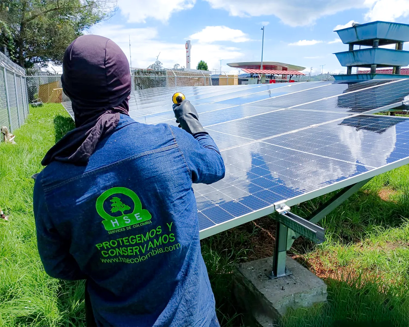 Inspección técnica de paneles solares en piso por técnico de HSE Colombia en estación de servicio